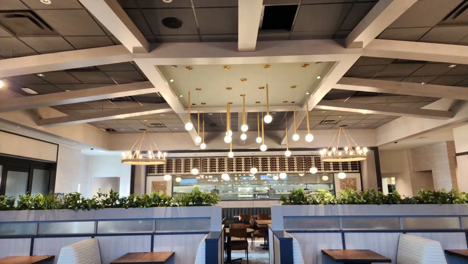 A restaurant with tables and chairs and a chandelier hanging from the ceiling