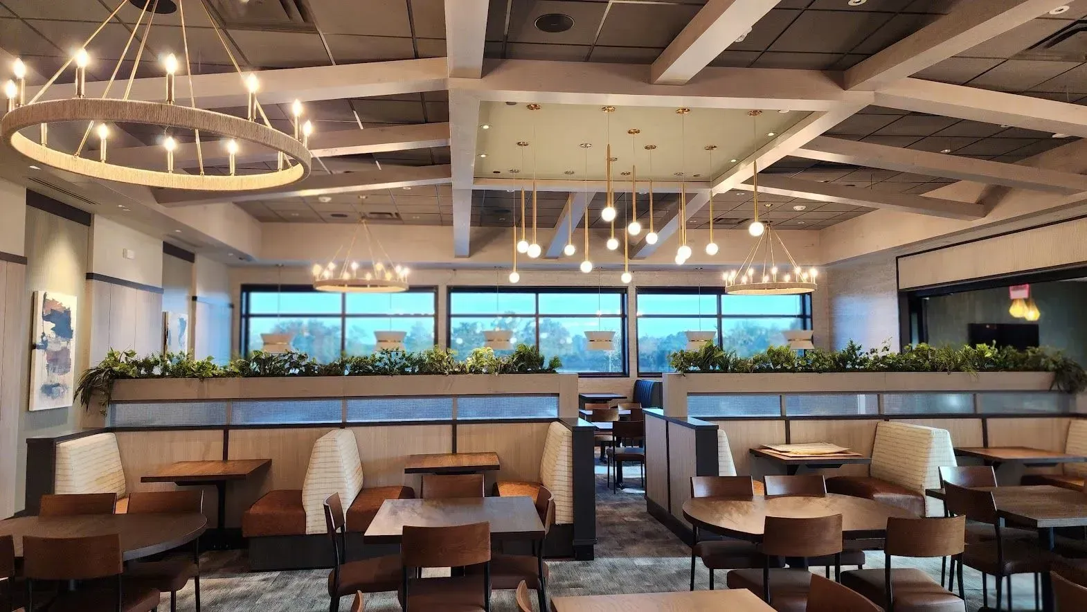 A restaurant with tables and chairs and a chandelier hanging from the ceiling.