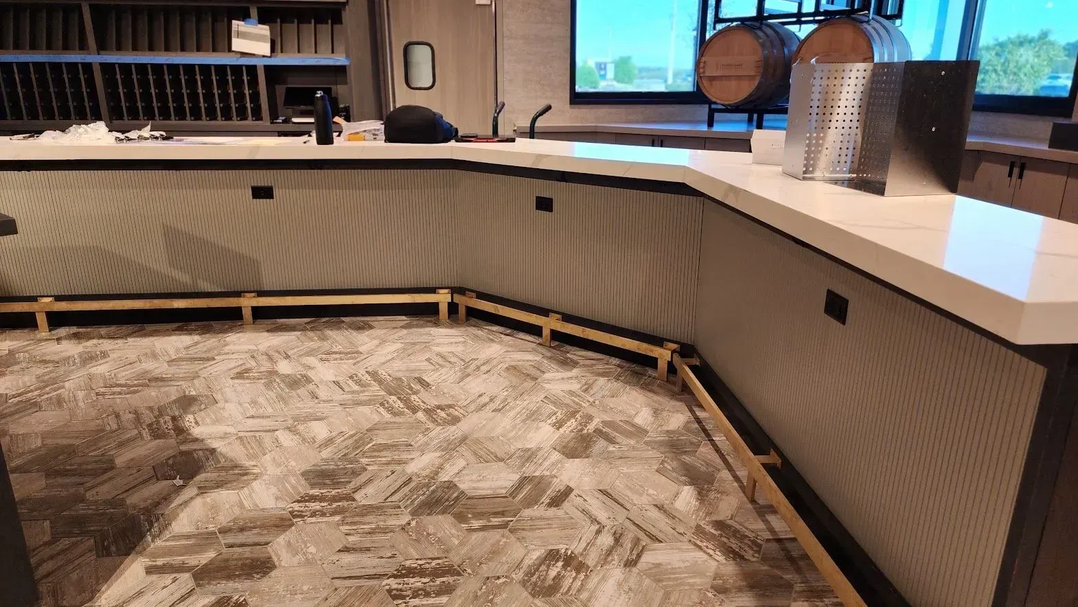 A kitchen with a long counter and a wooden floor.