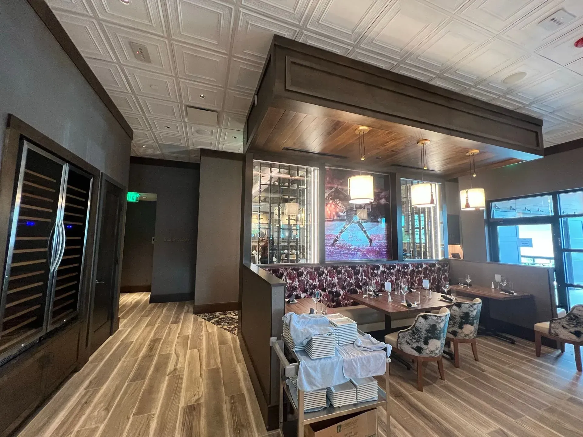 A restaurant with tables and chairs and a couch in the middle of the room.