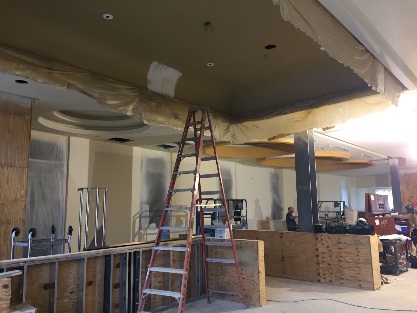 A ladder is sitting in the middle of a room under construction.