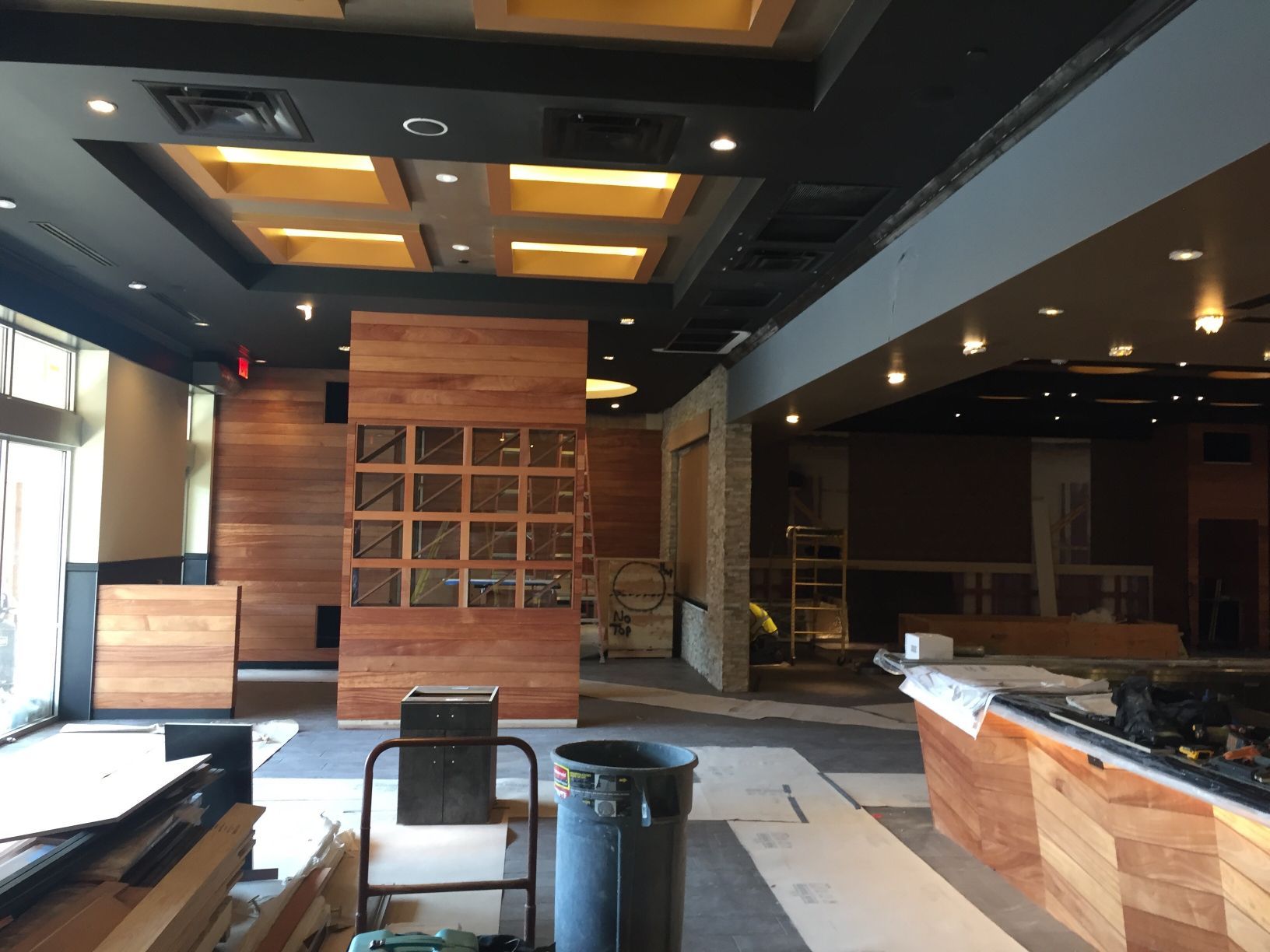 An empty room with a black trash can in the middle