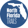 A green circle with the words north florida trails on it