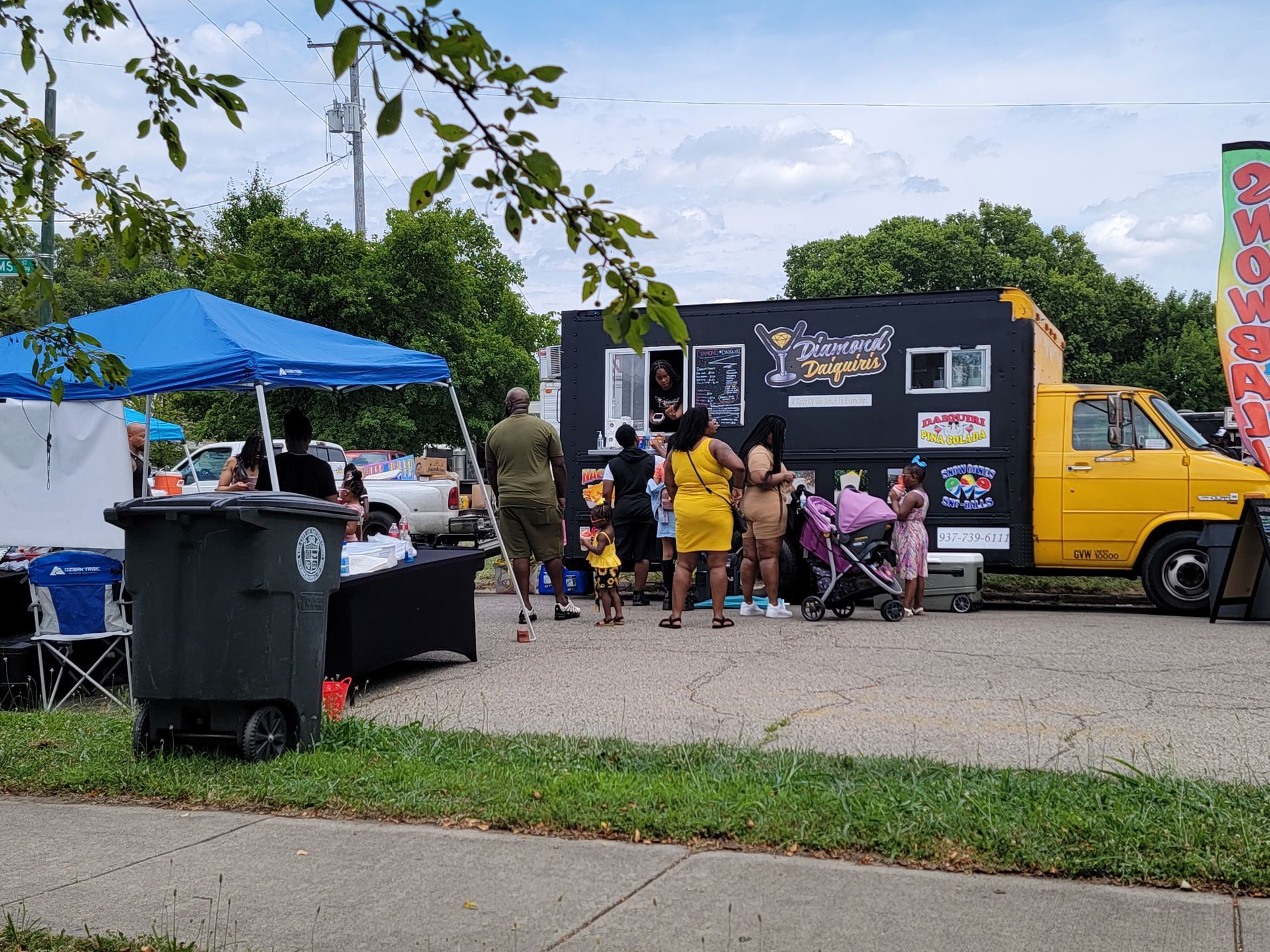 A group of people are standing in front of a food truck.