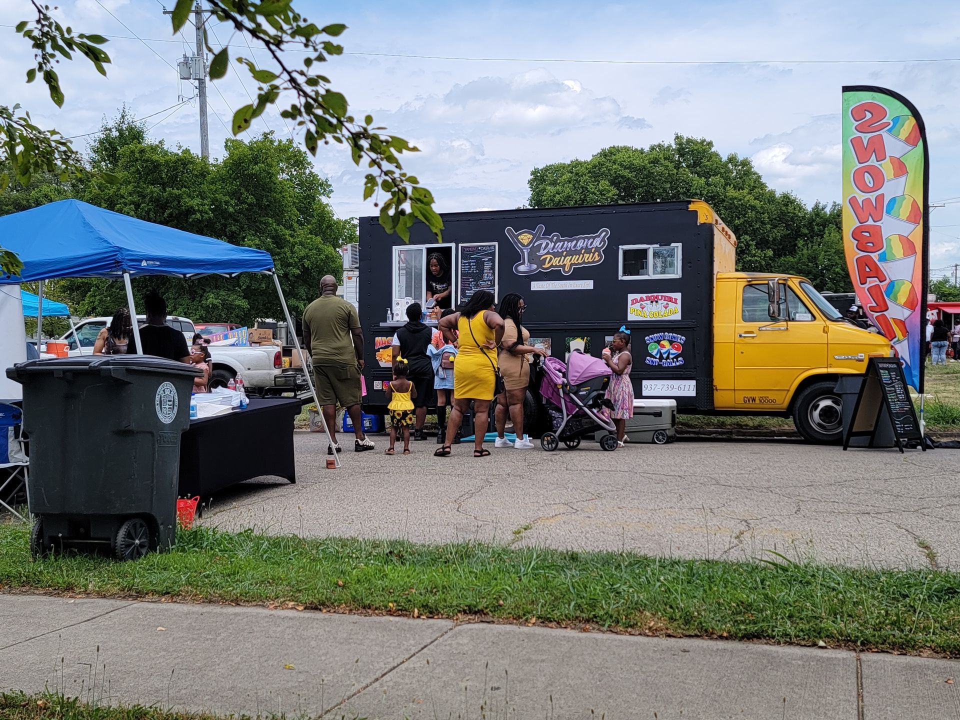 A group of people are standing in front of a food truck.