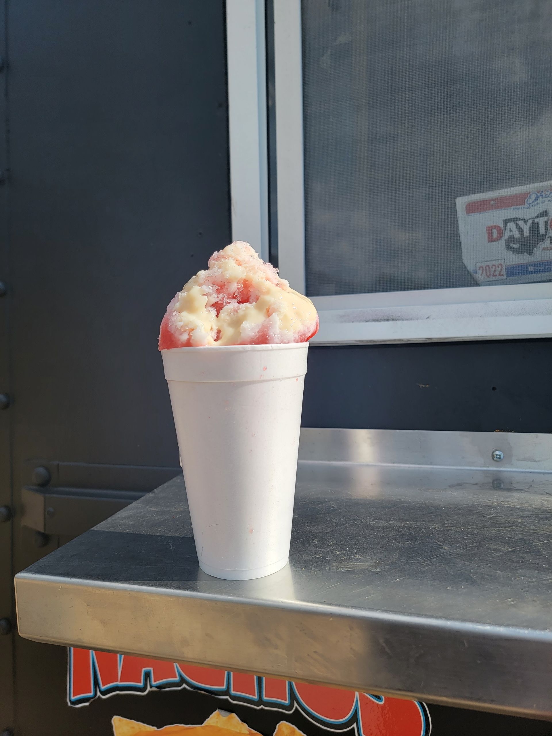 A cup of ice cream is sitting on a metal table