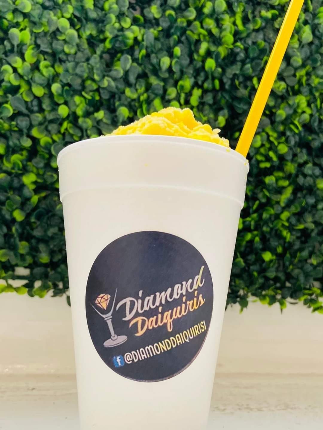 A cup of diamond daiquiris with a yellow straw