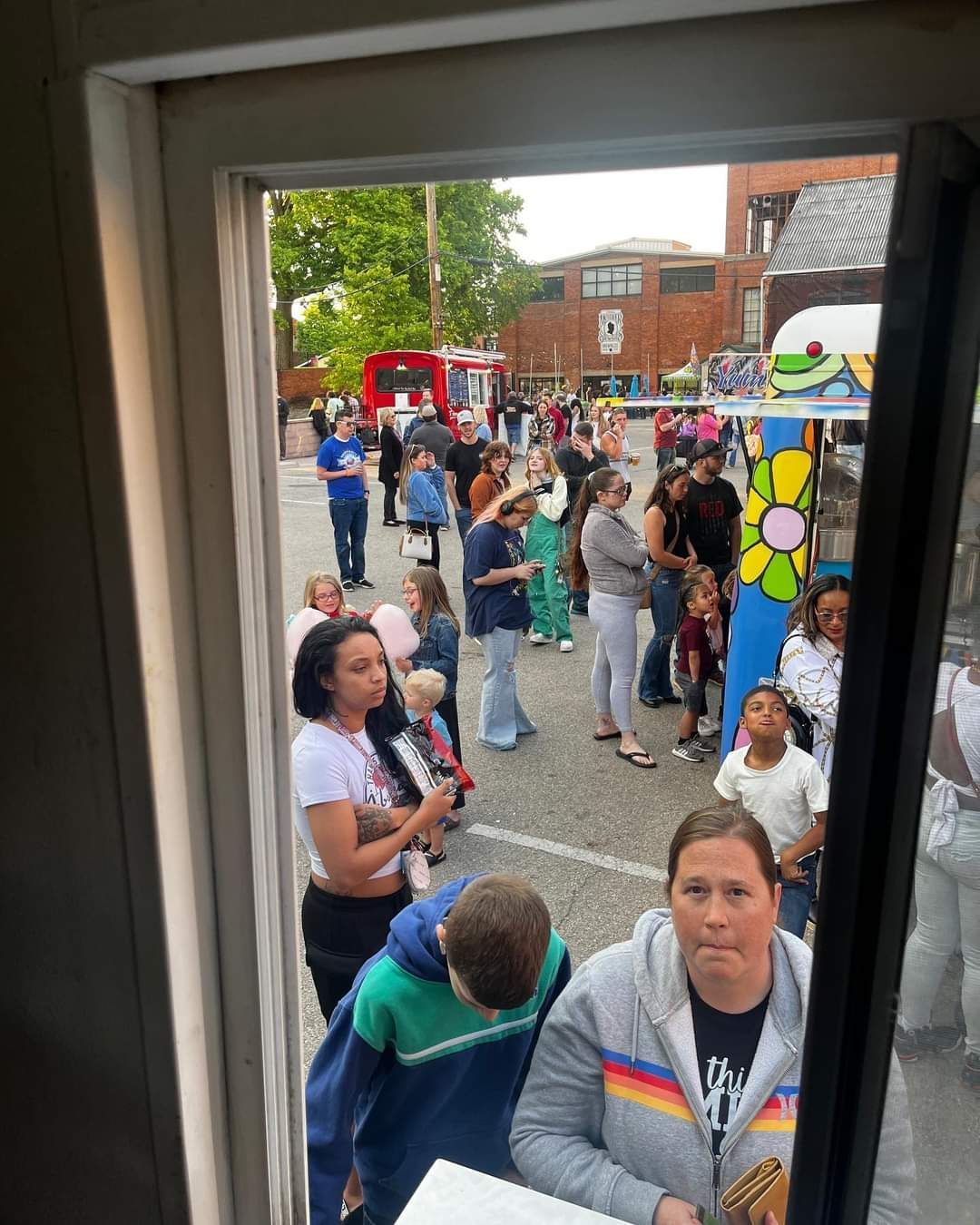 A group of people are standing in a line outside of a building.