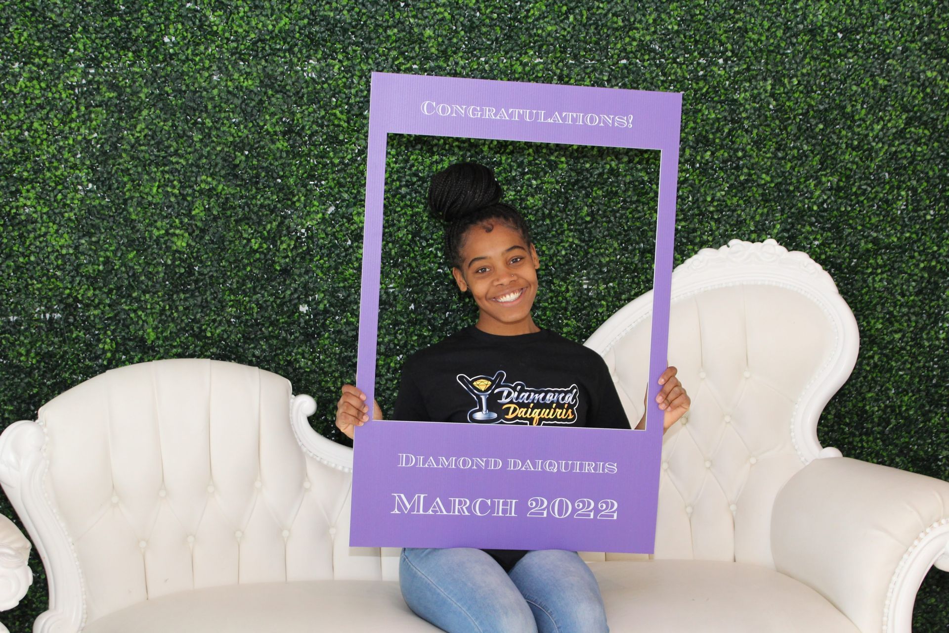 A woman is sitting on a couch holding a picture frame.