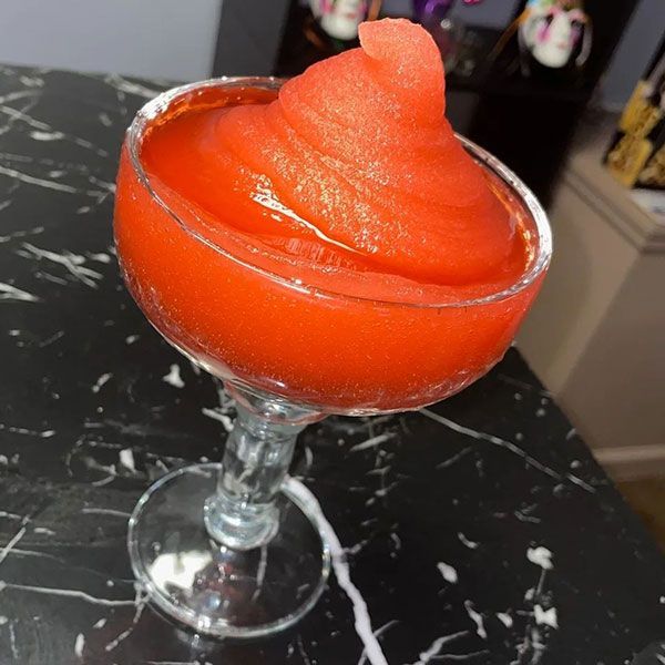 A glass filled with red liquid on a table
