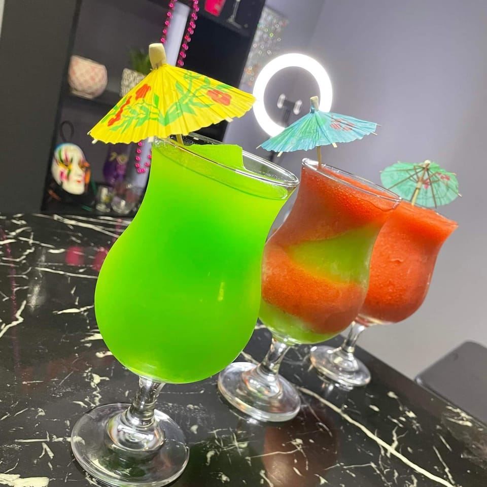 Three drinks with umbrellas on them are on a table