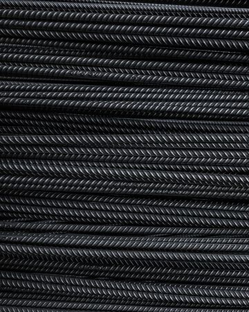 Primer plano de cables trenzados negros apilados con un patrón de tejido diagonal texturizado.