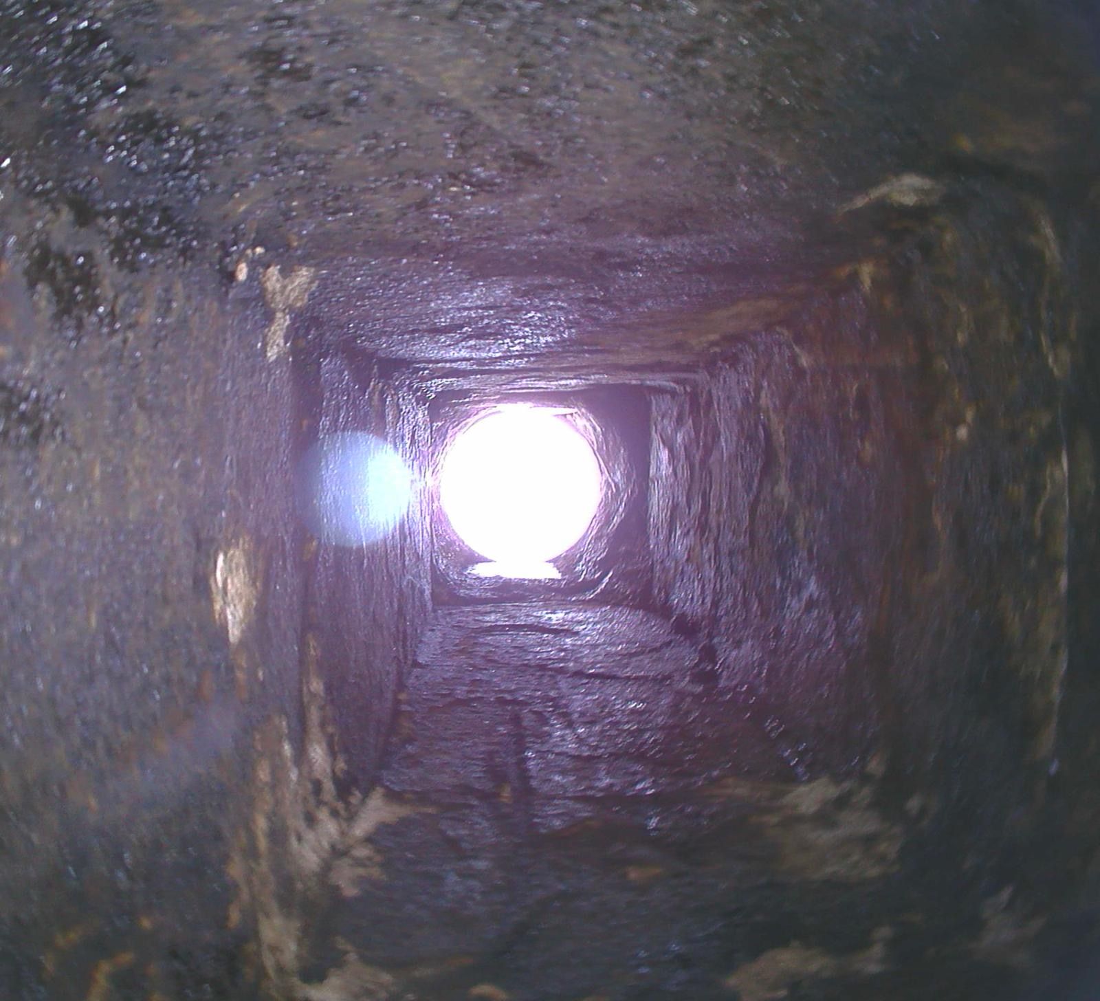 Chimney inspection setup: Camera on a stand displays the interior. 
