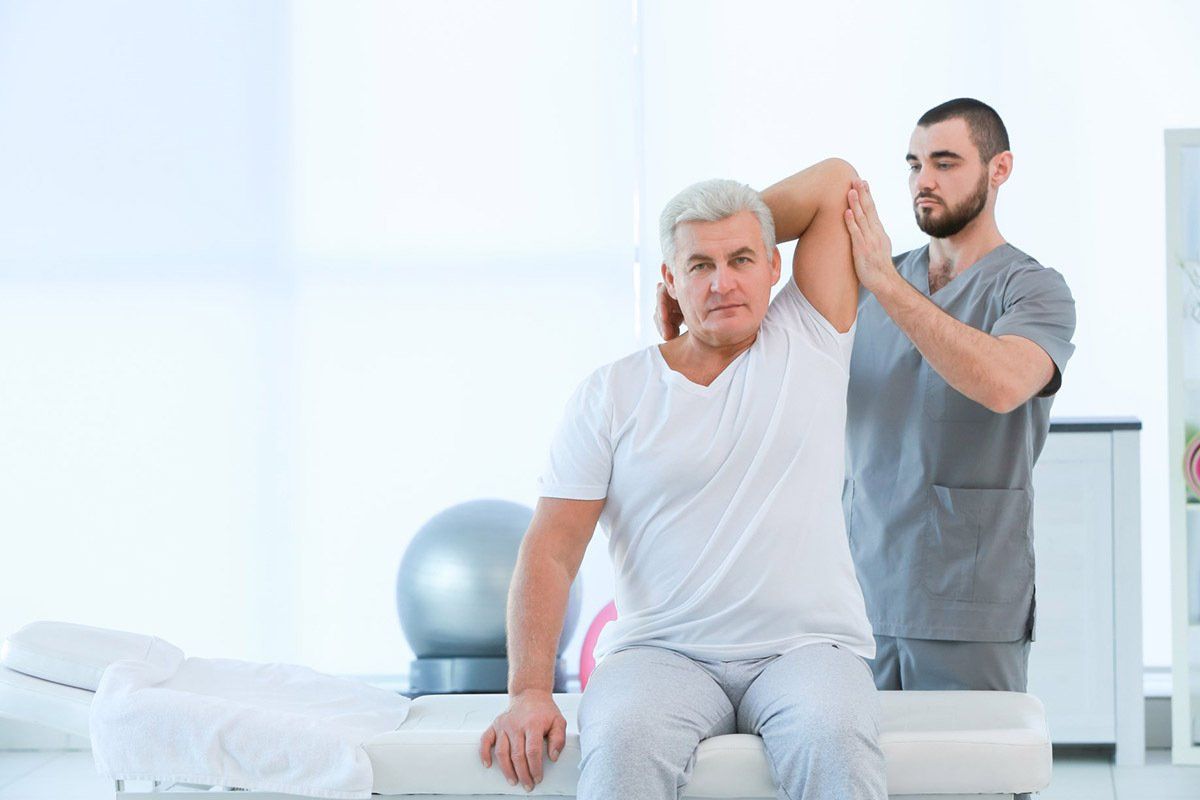 Men Physiotherapist Working With Patient —