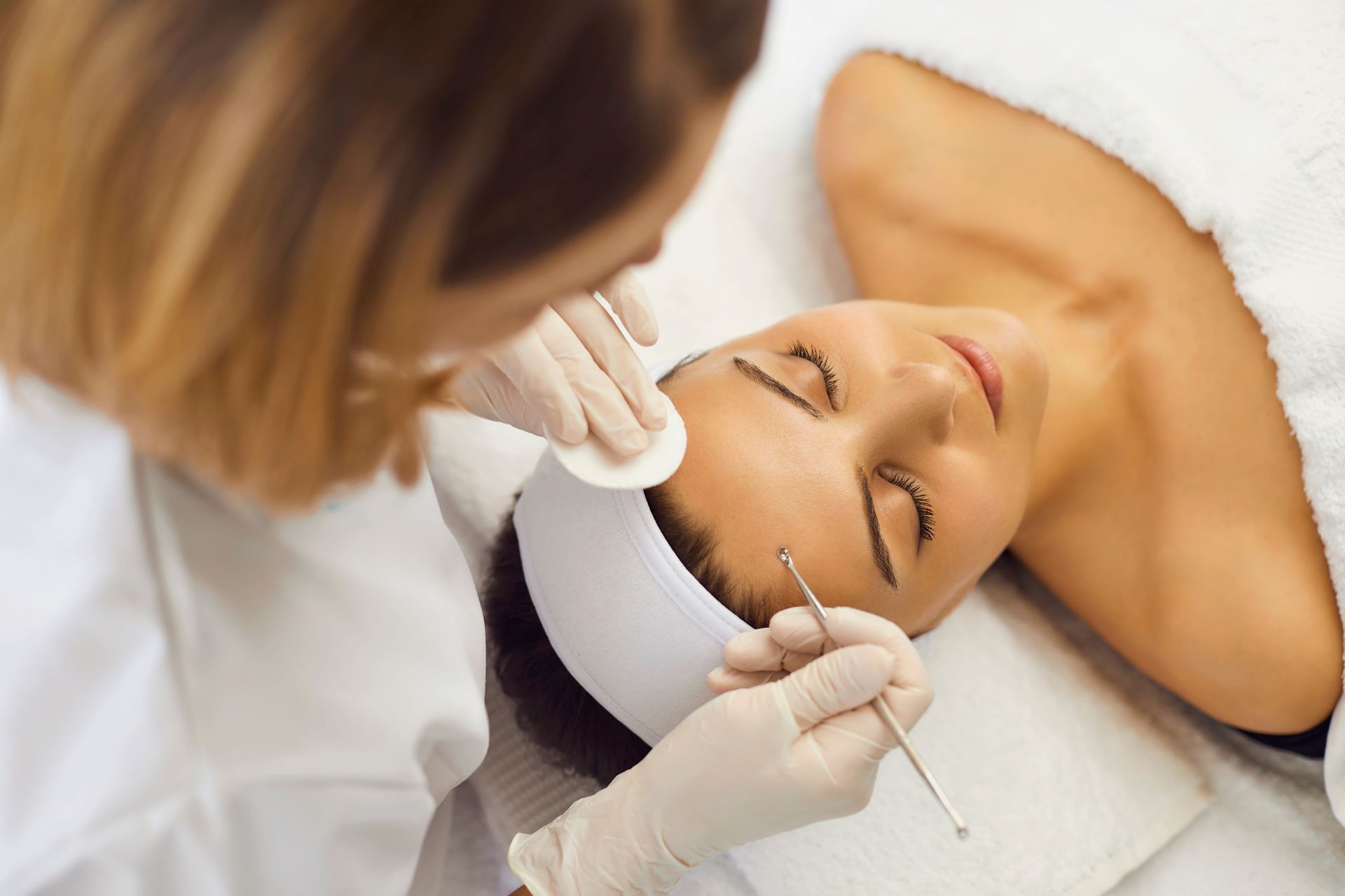 A woman is getting a facial treatment at a beauty salon.