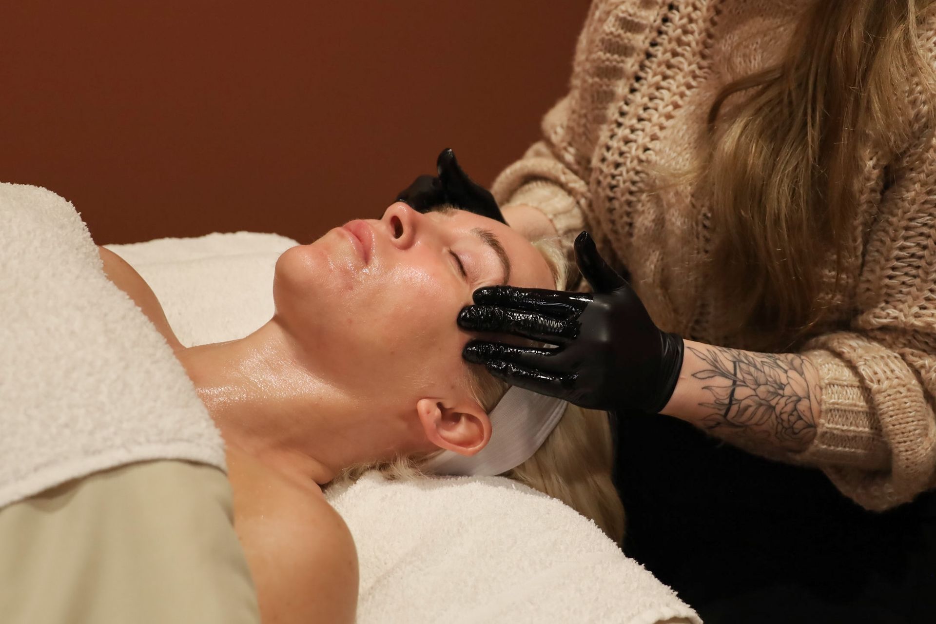 A woman is getting a massage on her face at a spa.