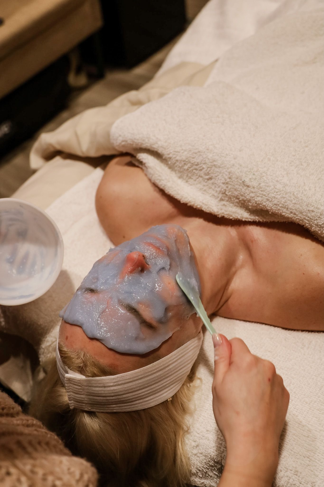 A woman is getting a facial treatment at a spa.