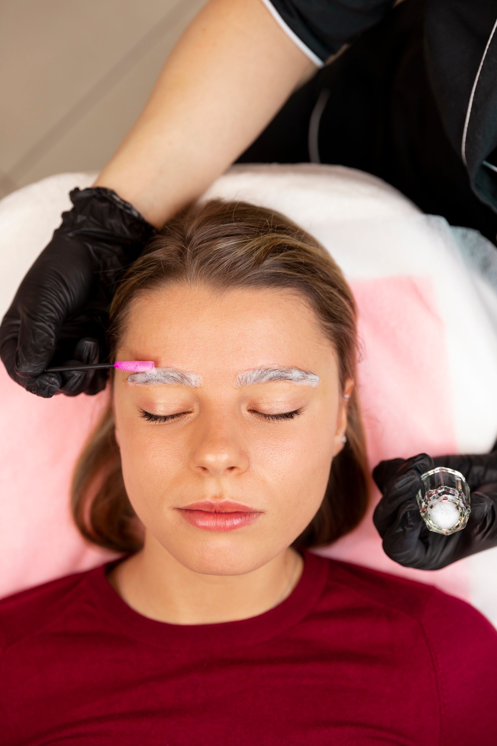 A woman is getting her eyebrows painted in a beauty salon.