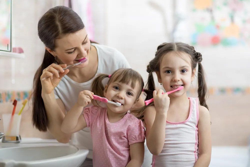 Mom and Two Daughters Brush Their Teeth — Amherst, OH — Gregory Sy, DDS