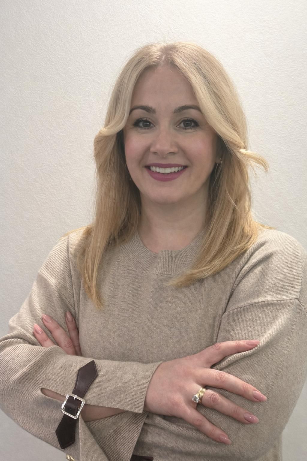 Een vrouw in een turquoise jurk staat voor een winkelpui die versierd is met een ballonnenboog.