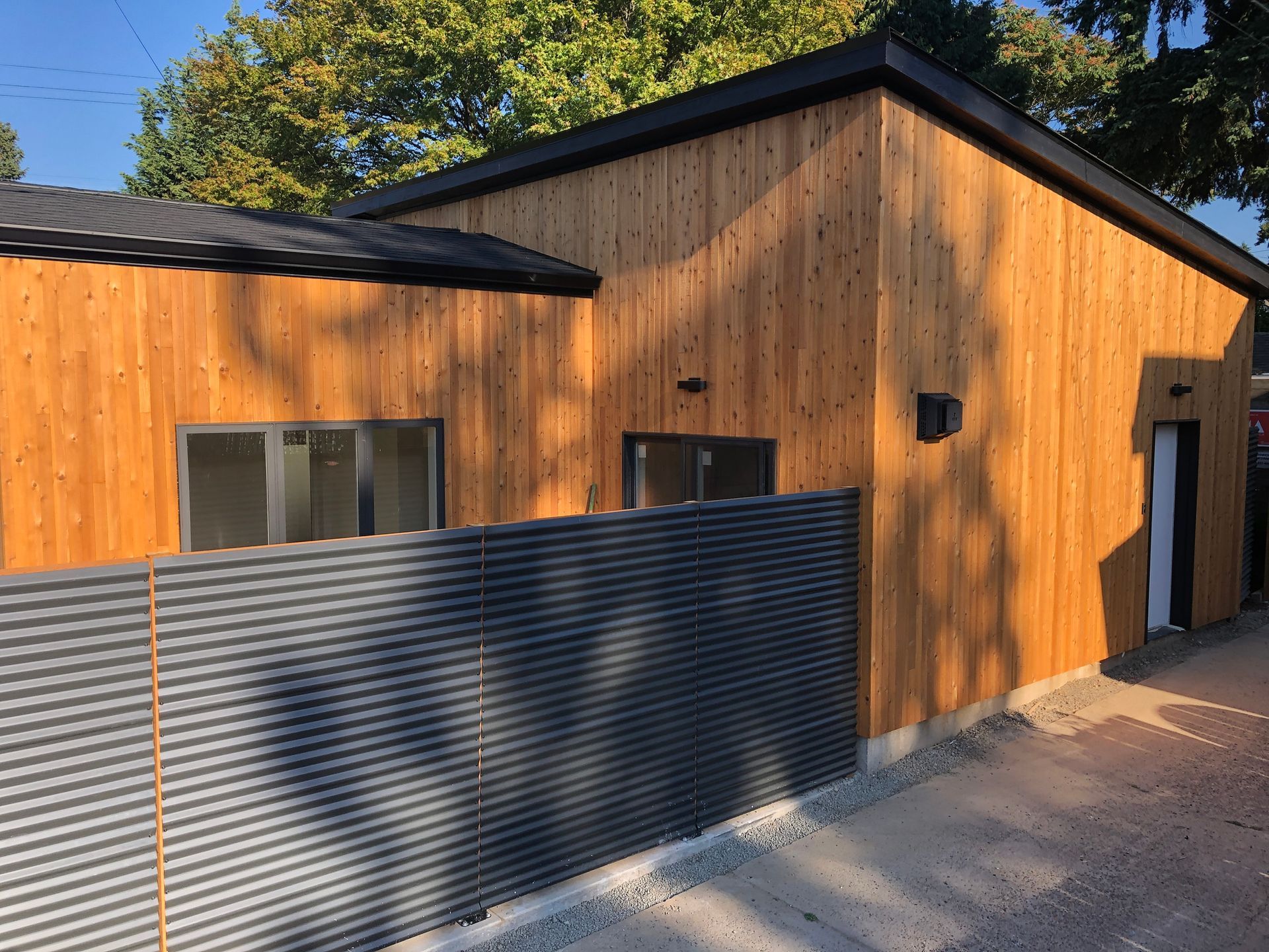 A wooden house with a metal fence in front of it