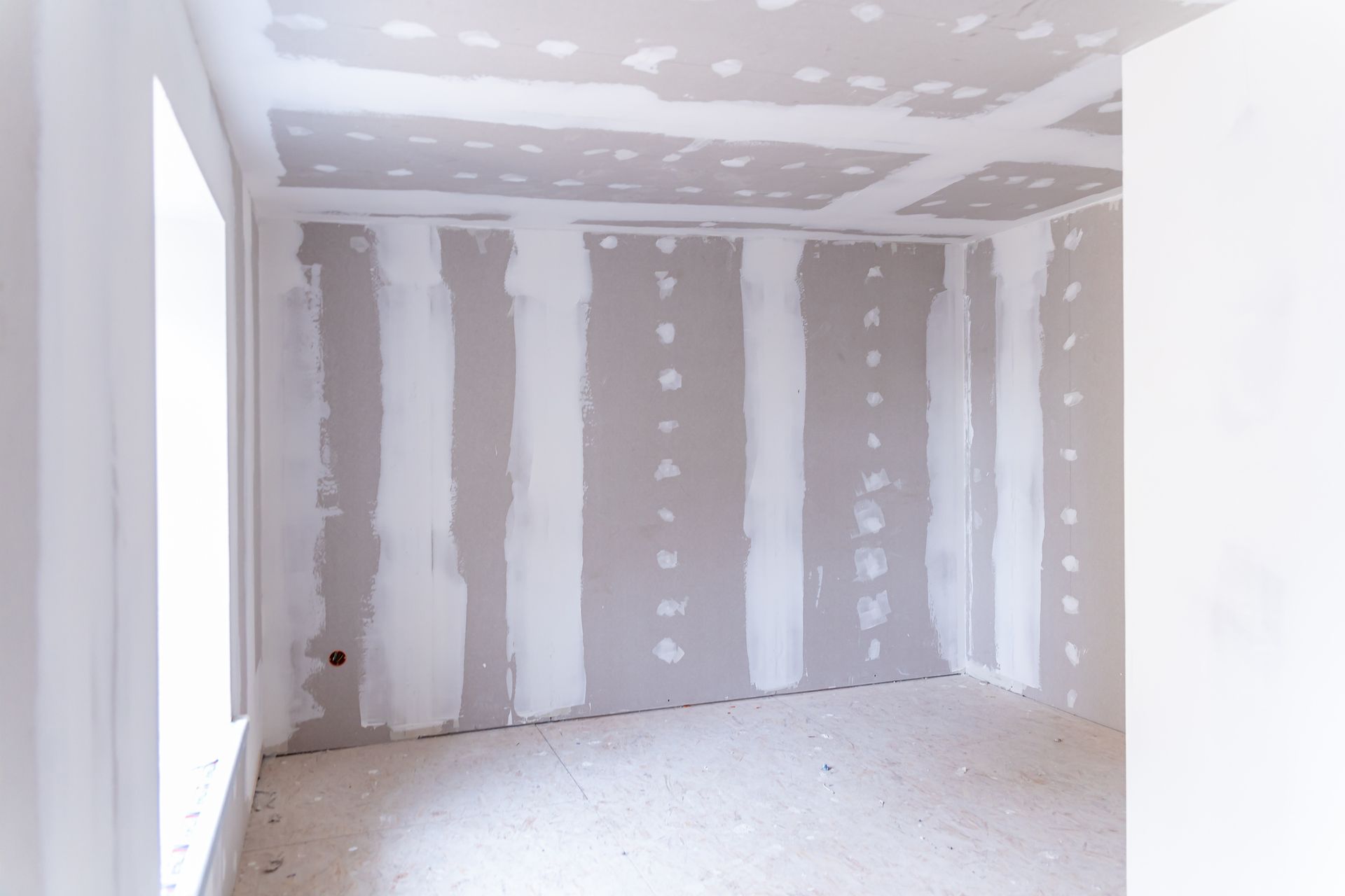 An empty room with drywall on the walls and ceiling