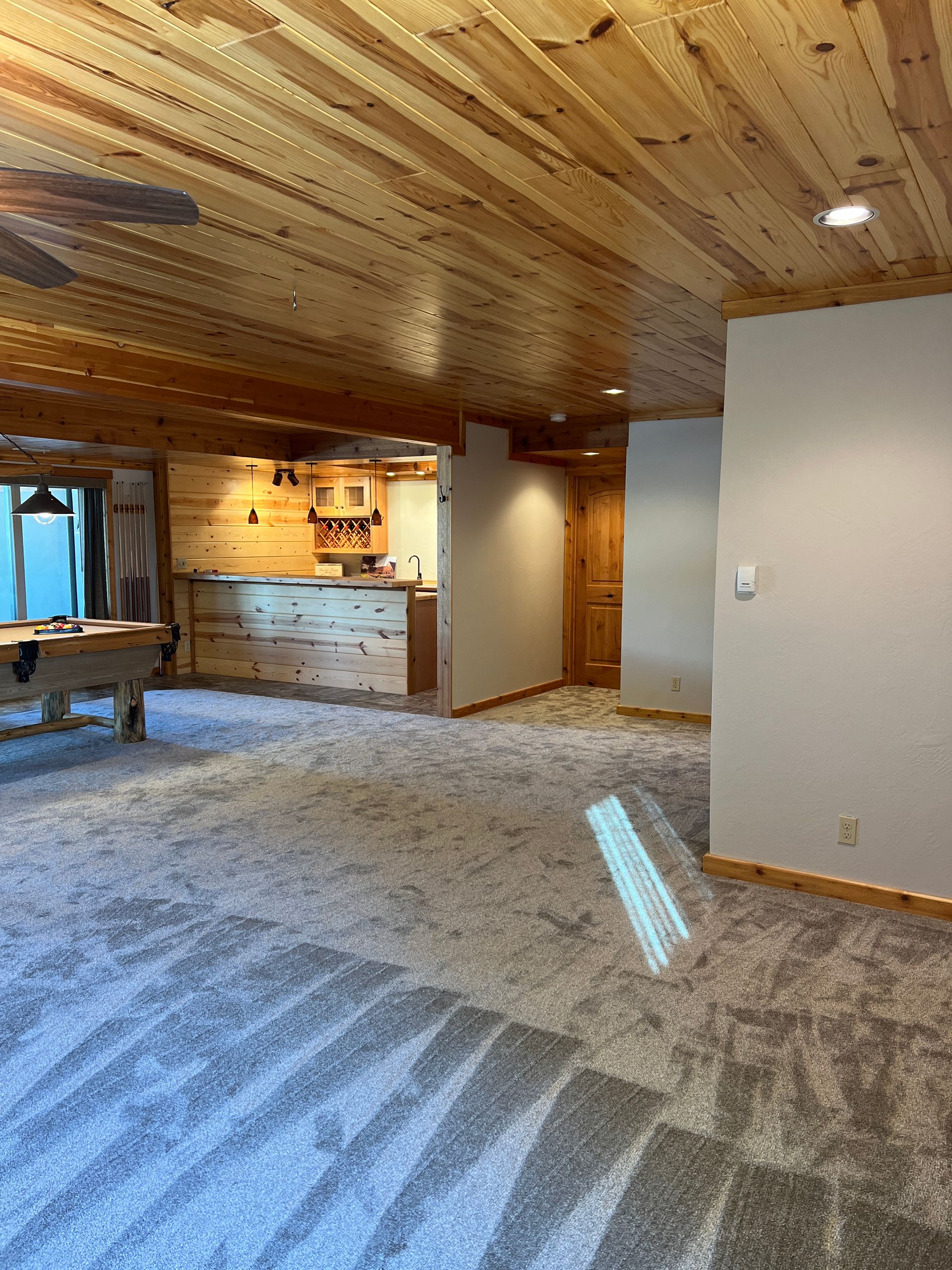 A hallway with a door that is open to a living room and dining room.