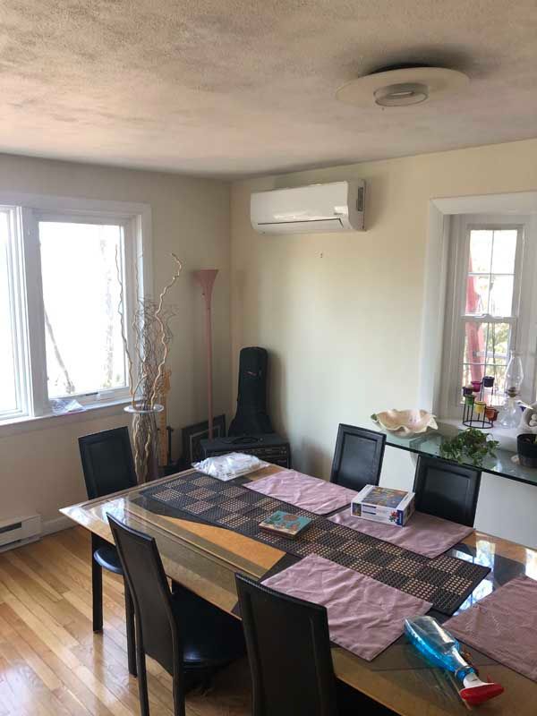 Dining room with table, chairs, air conditioner, and windows.