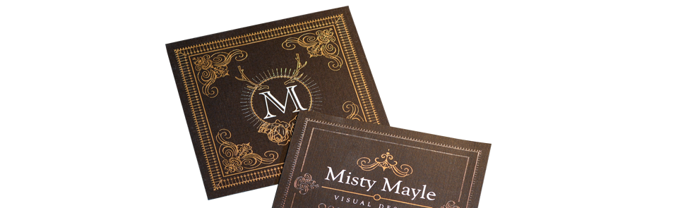 Two business cards are sitting on top of each other on a white surface.