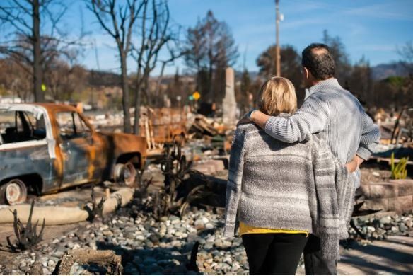 A family reflects upon the rubble that was once their house. Fire can be devastating.