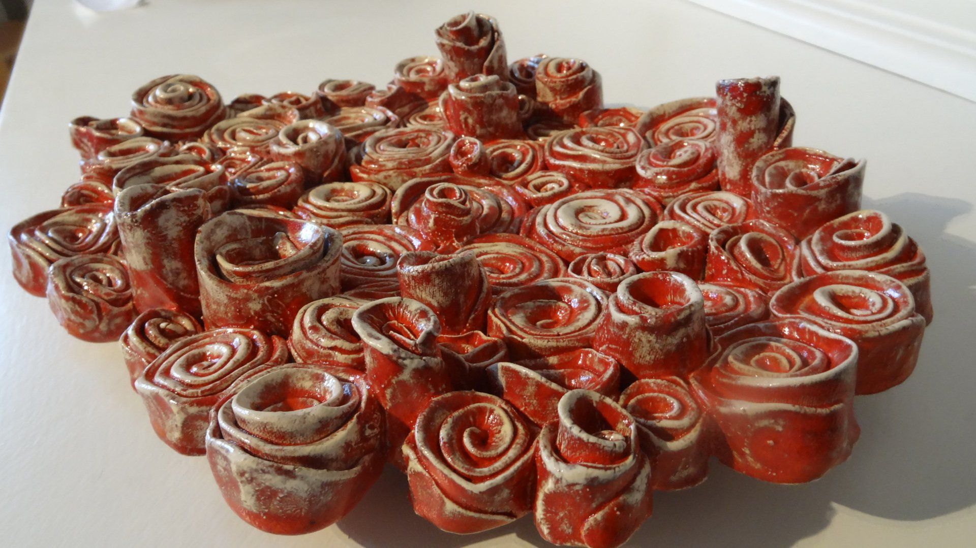 schaal opgebouwd van rode keramiek rolletjes