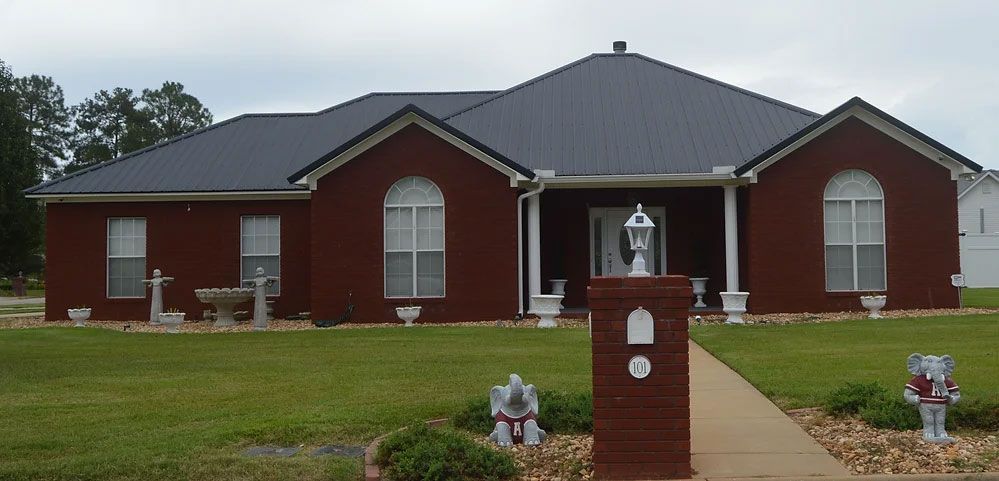 A large red brick house with a black roof
