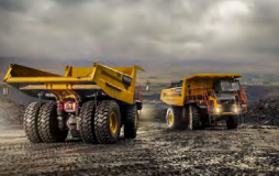 Two Large Yellow Dump Trucks in a Mine, Against a Cloudy Sky — Northern Heavy Machinery in Mount Louisa, QLD
