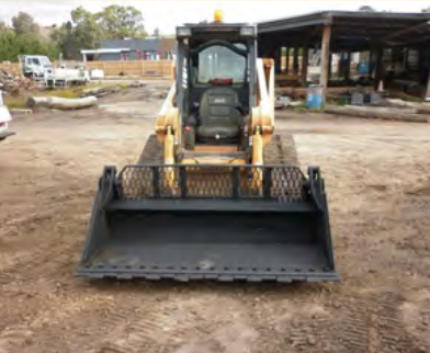 Yellow Skid Steer Loader With Bucket on Dirt Surface — Northern Heavy Machinery in Mount Louisa, QLD