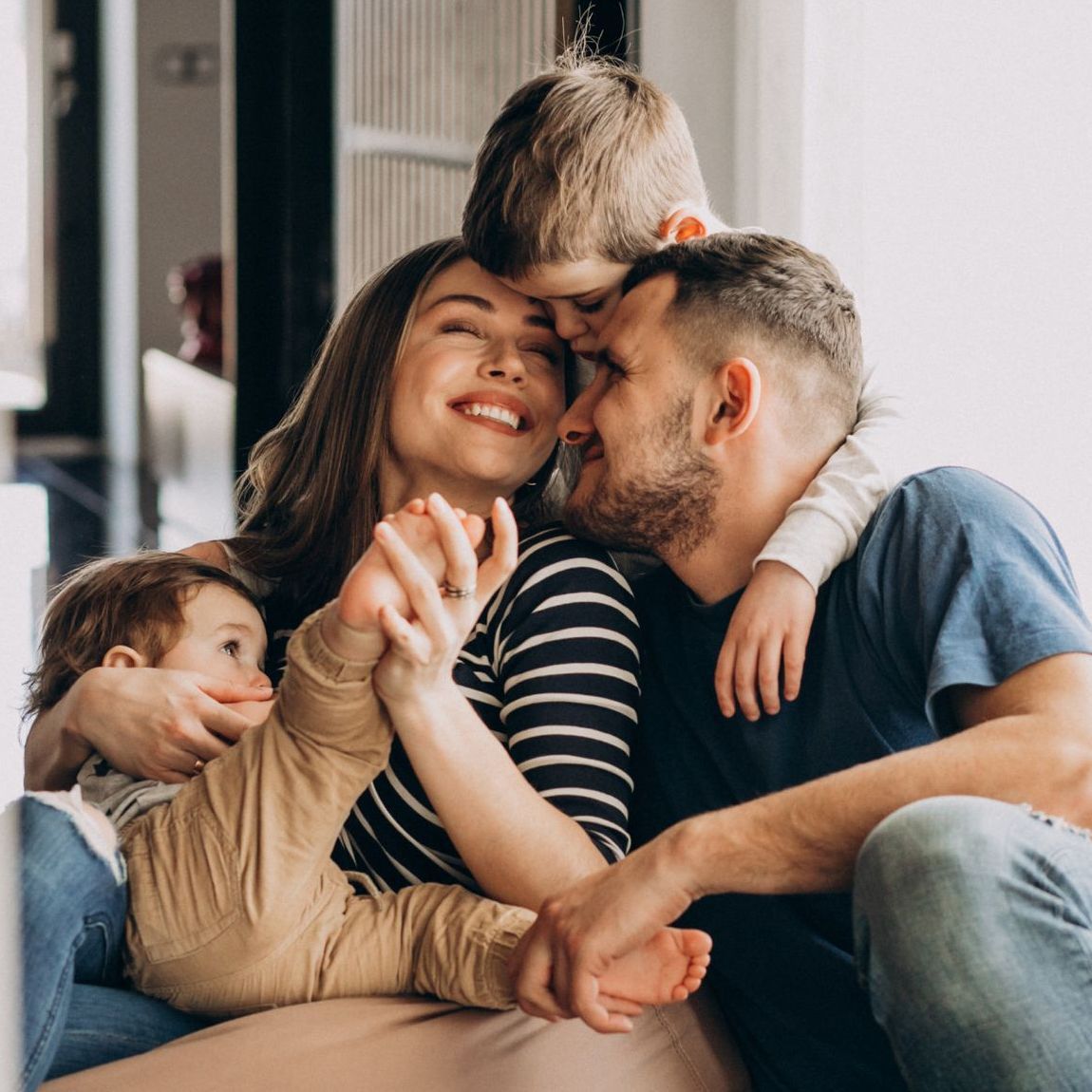 A man and woman are sitting on the floor with two children.