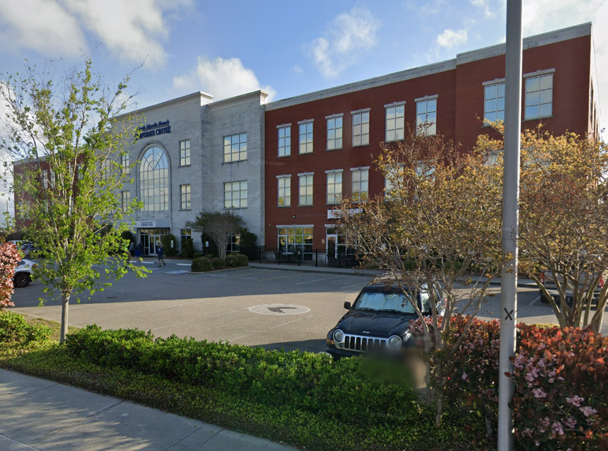 A car is parked in front of a large building