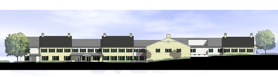 Building with light yellow walls, dark roof, and small trees on either side, under a blue sky.