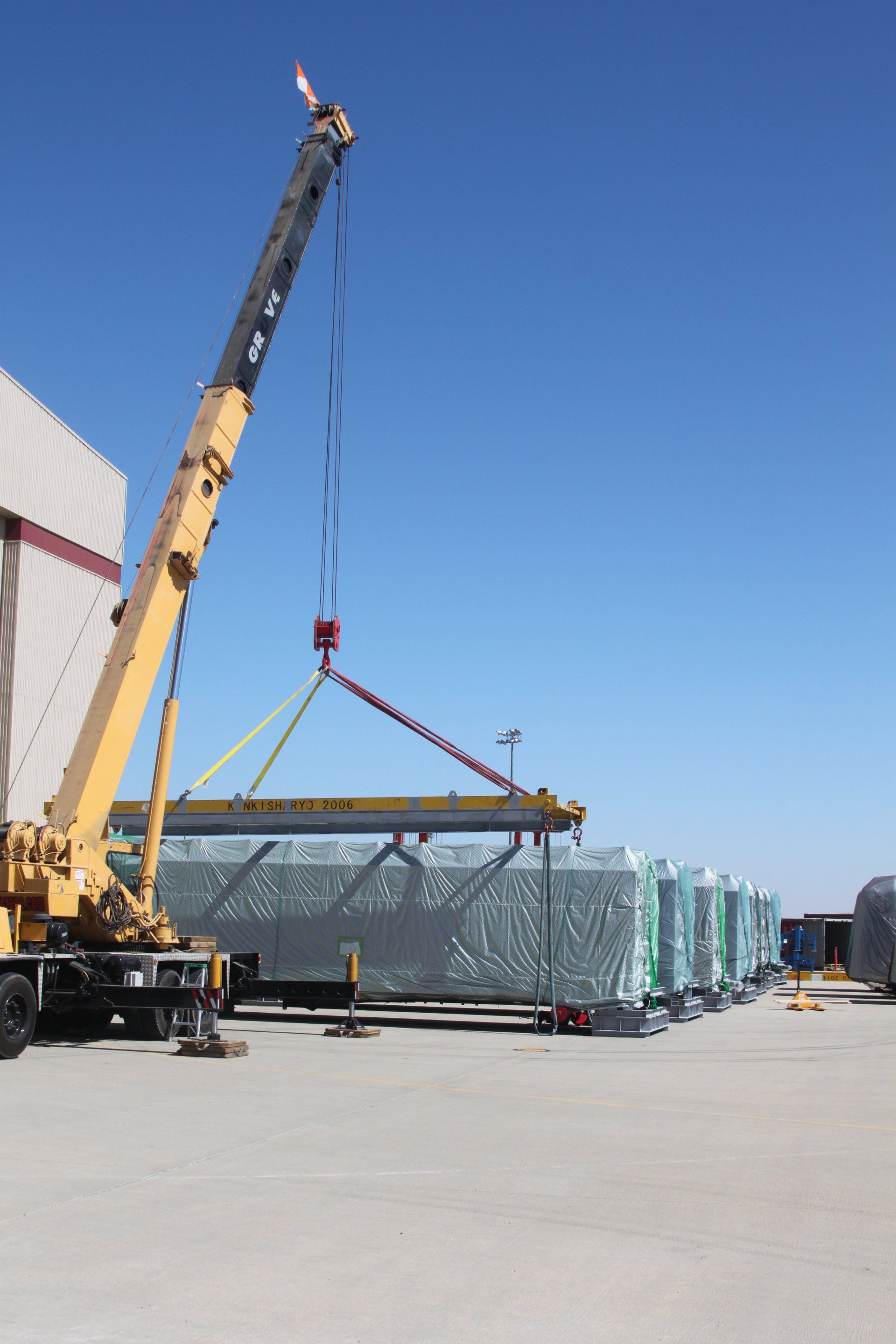 Yellow Crane Lifting a Metal — Lancaster, CA — Get Hooked Crane Service