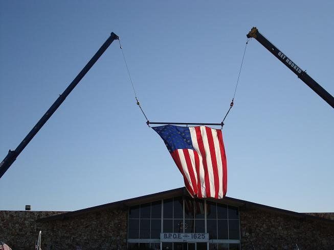 US Flag Lifted by Cranes — Lancaster, CA — Get Hooked Crane Service
