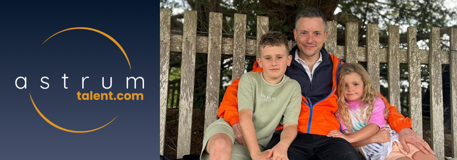 astrum talent logo with man wearing orange coat sat between a boy and a girl