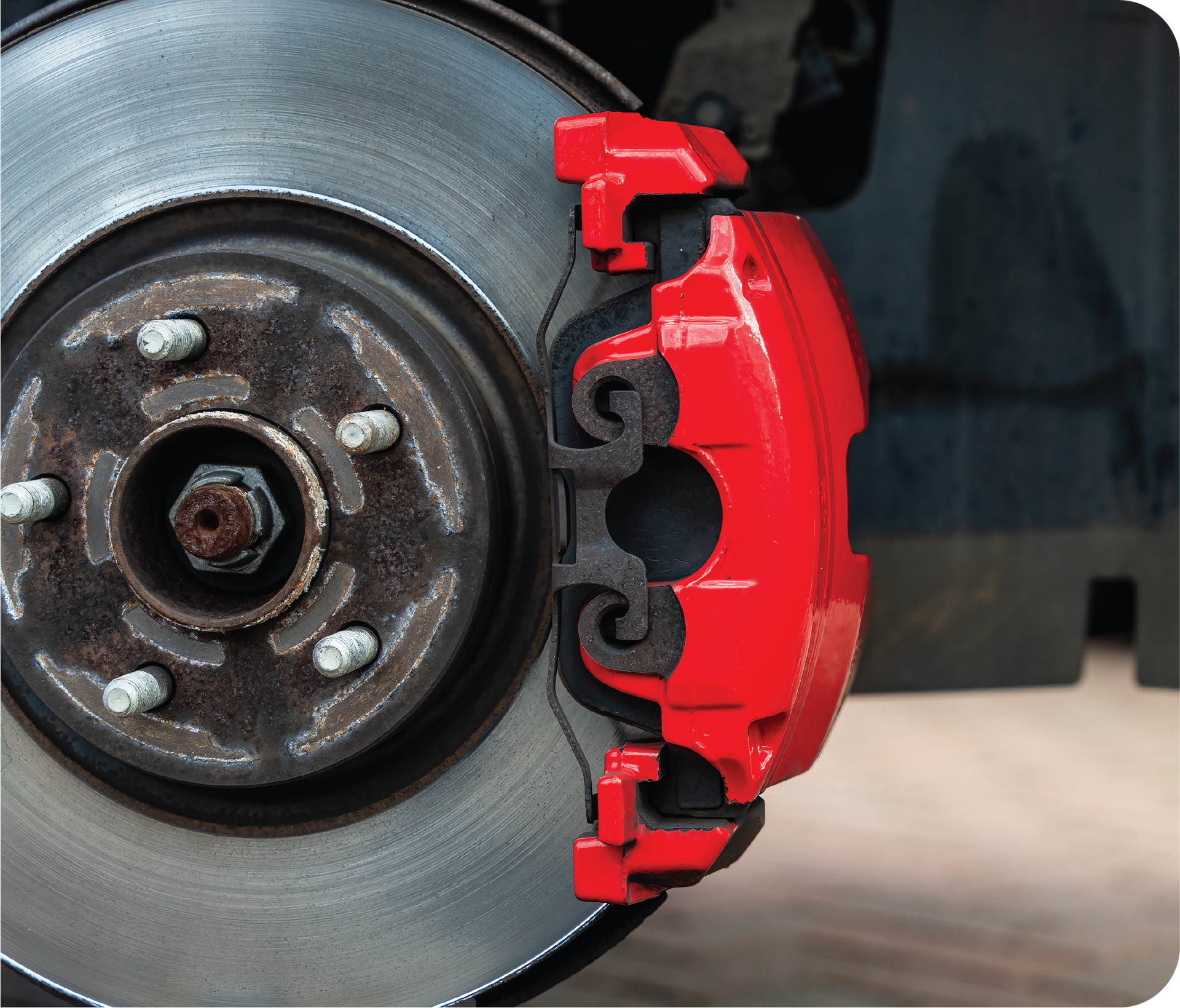 A close up of a red brake caliper on a car
