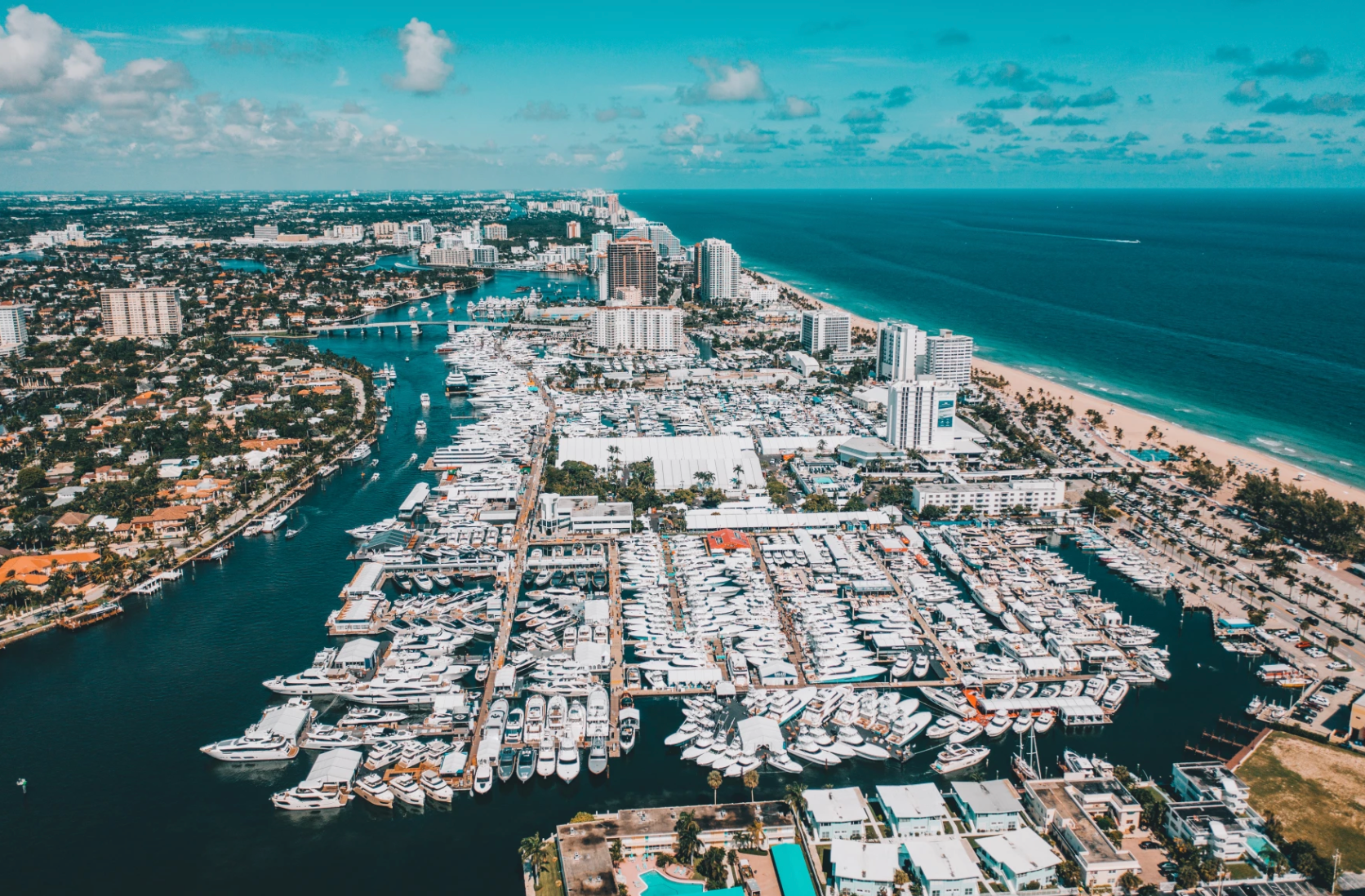 An aerial view of a city with a lot of boats in the water.