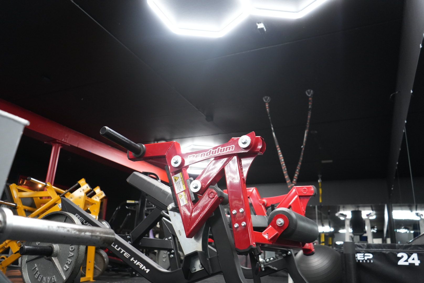 A red motorcycle is parked in a gym.