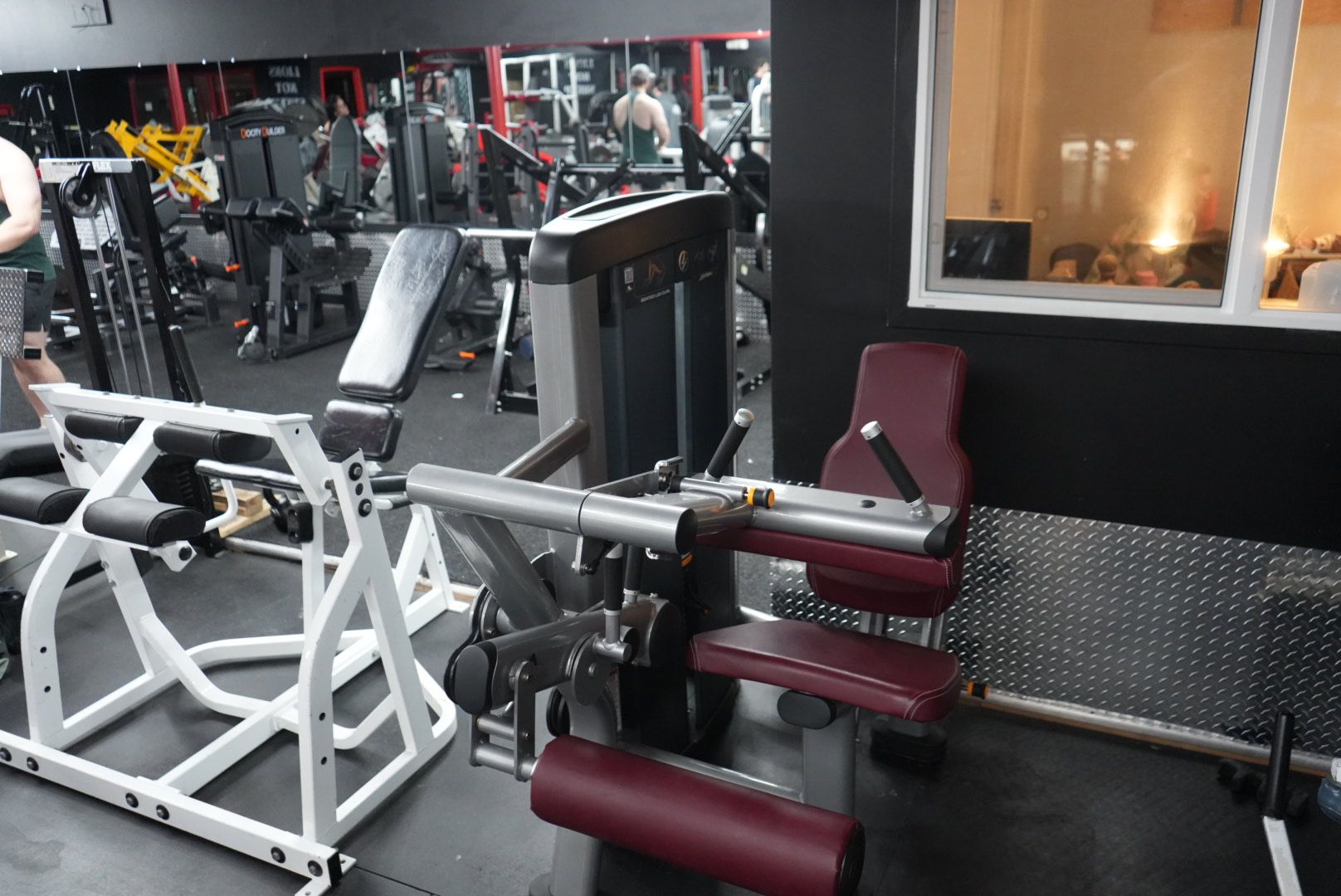 A gym with a lot of exercise equipment and a large mirror.