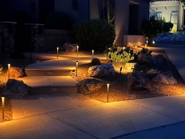 A row of candles in the desert with a cactus in the background