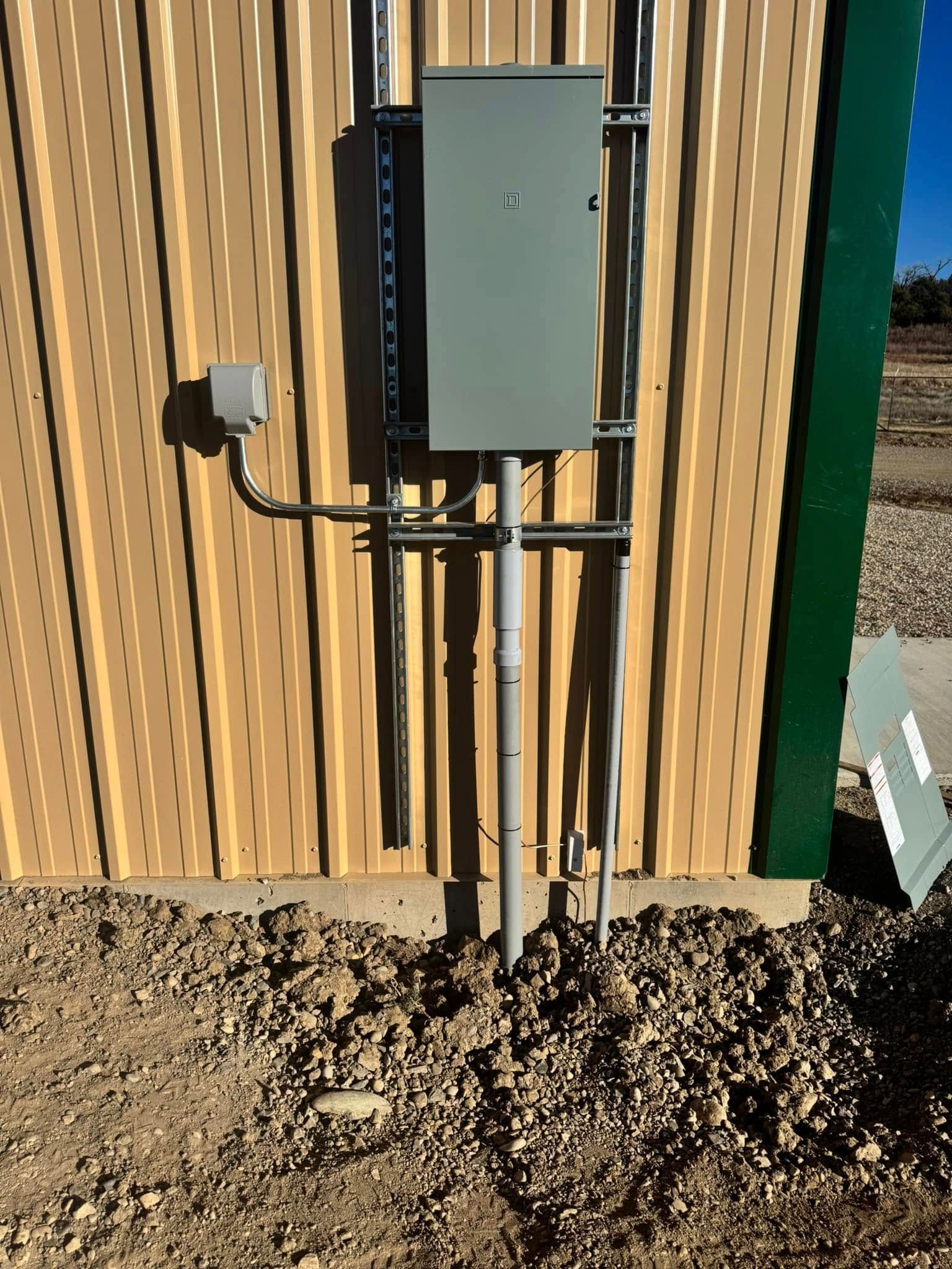 A electrical box is attached to the side of a building.