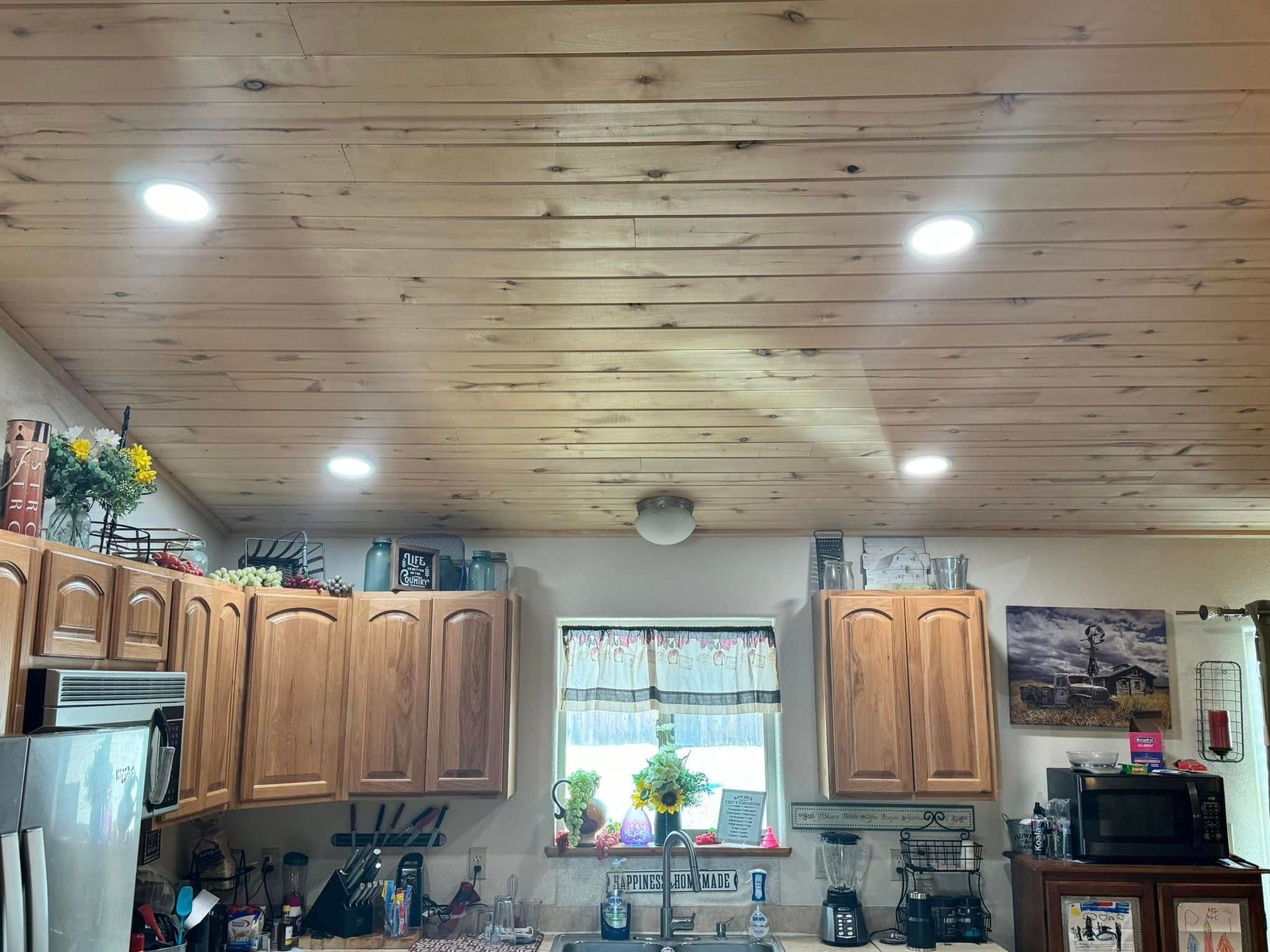 A kitchen with wooden cabinets and a wooden ceiling