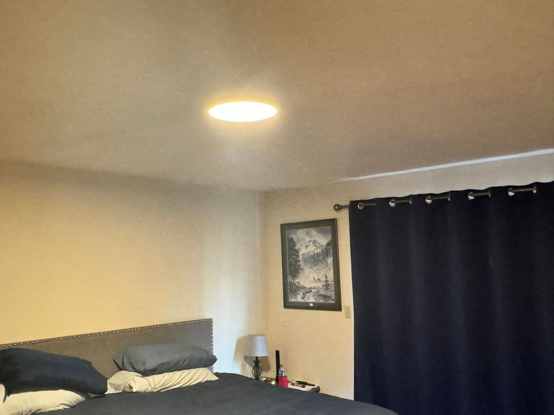 A bedroom with a bed and a picture on the wall