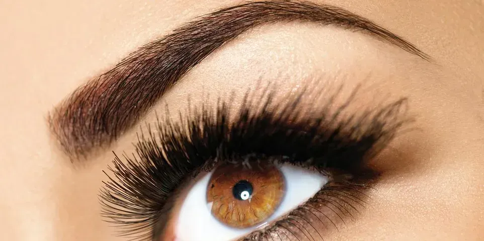 a close up of a woman 's eye with long eyelashes