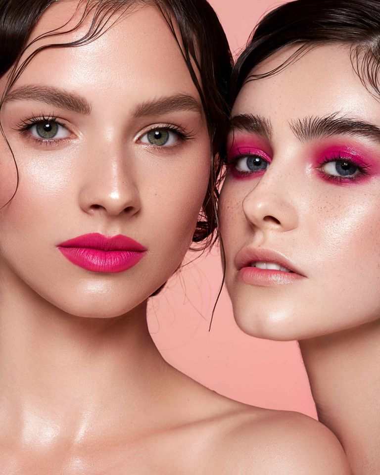two women with pink makeup on their faces are standing next to each other